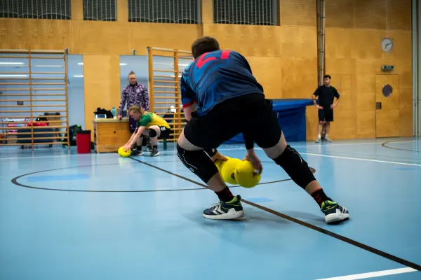 Dodgeball player dodging low to pick up a ball
